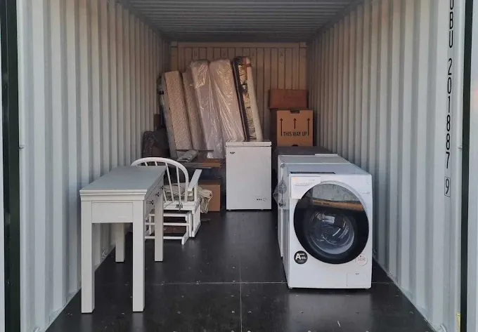 Electrodomésticos, colchones y muebles ordenados en un trastero contenedor