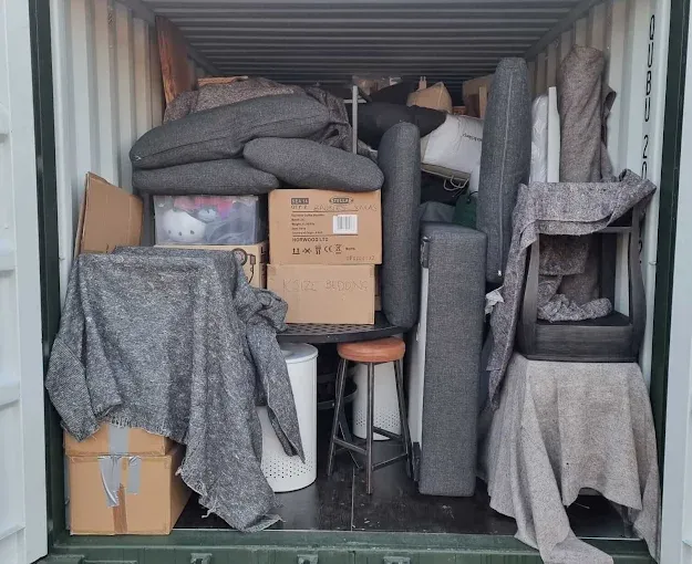 Muebles y cajas de una mudanza guardados dentro de un trastero contenedor